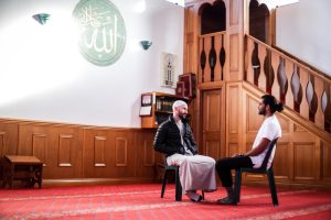 A man and a support coordinator sitting on chairs, discussing NDIS for mental health.