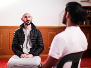 Two men in conversation, highlighting innovative community participation through meaningful, inclusive dialogue in a supportive environment.