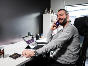 Man in office on a phone call, researching transport options for accessibility.