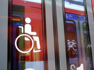 Wheelchair access sign on a train door, indicating travel assistance for passengers with disabilities.