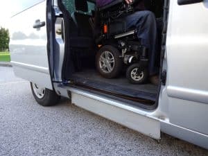 A wheelchair-accessible van with a ramp extended for easy medical transport assistance.