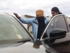 Two men inspecting a black SUV, discussing transport services for disabled individuals, ensuring accessibility and comfort.