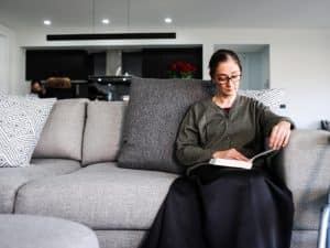 Woman reading quietly at home after participating in ndis community events.