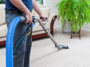Professional using steam machine for cleaning carpet stairs in a home living room