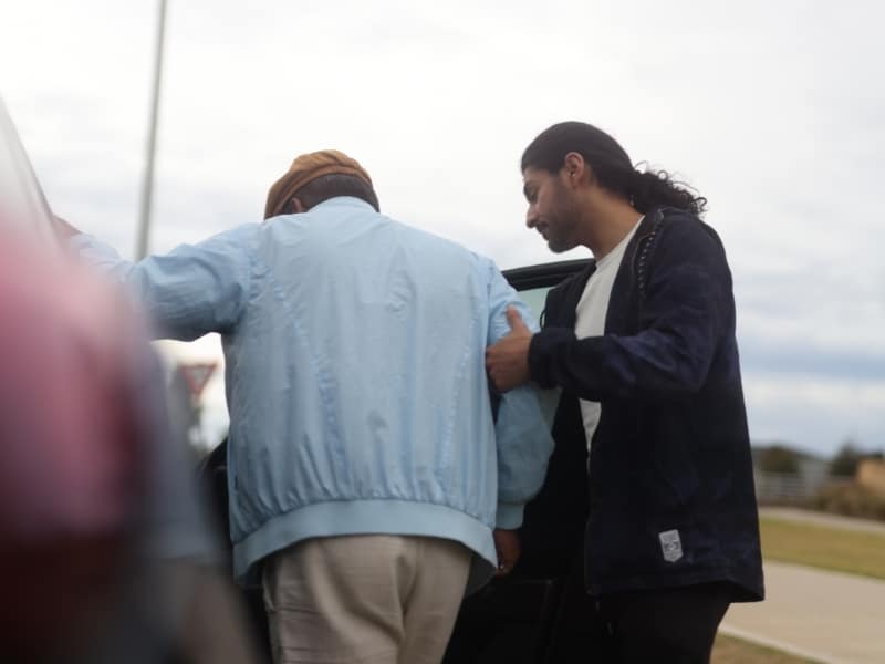 Elderly man receiving assistance into vehicle under ndis transport guidelines