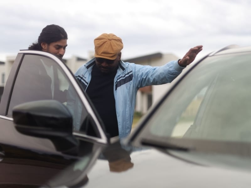 Discussing transport options for disabled people while inspecting a car.