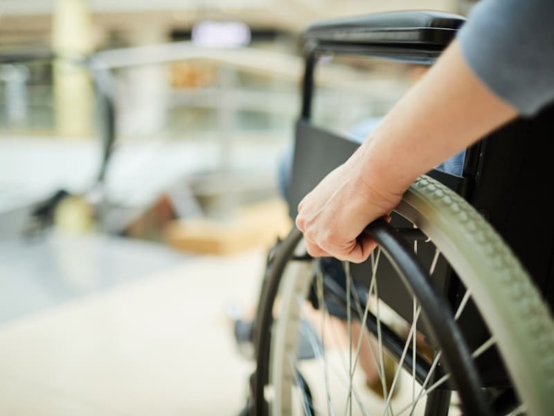 Manual wheelchair use highlights transport options for disabled people in public areas.