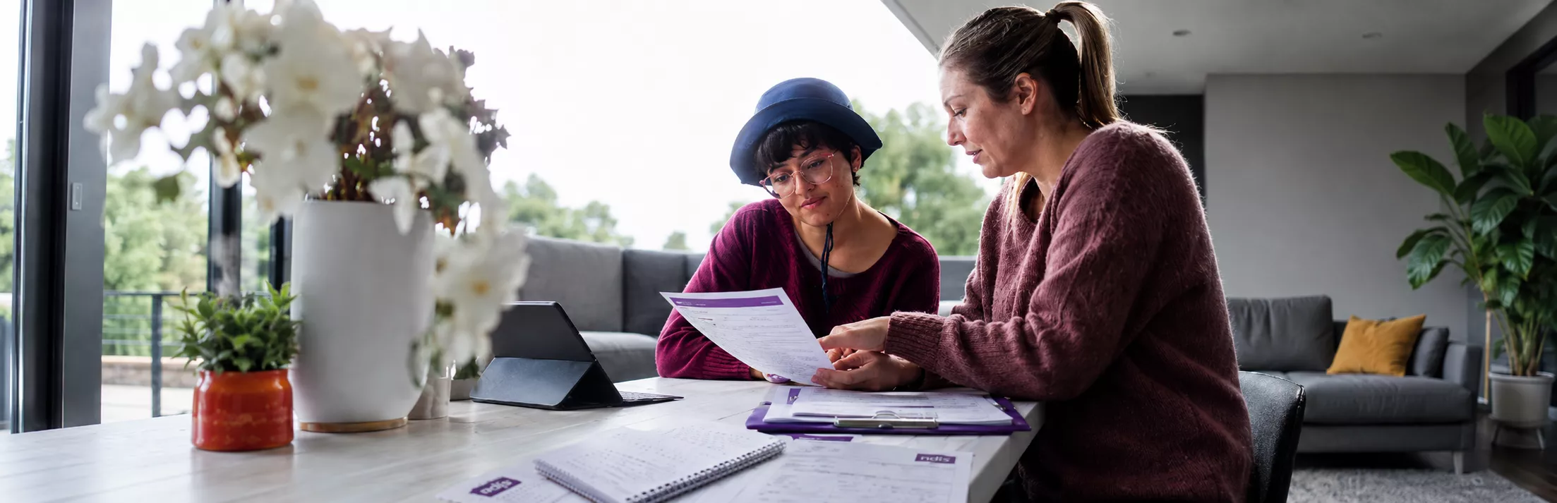 A support worker helping a participant with documents in Auburn