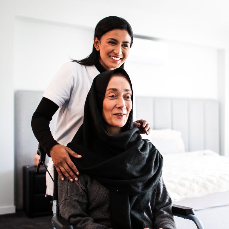 Support worker assisting a participant on the stairs inside an older home in Boroondara