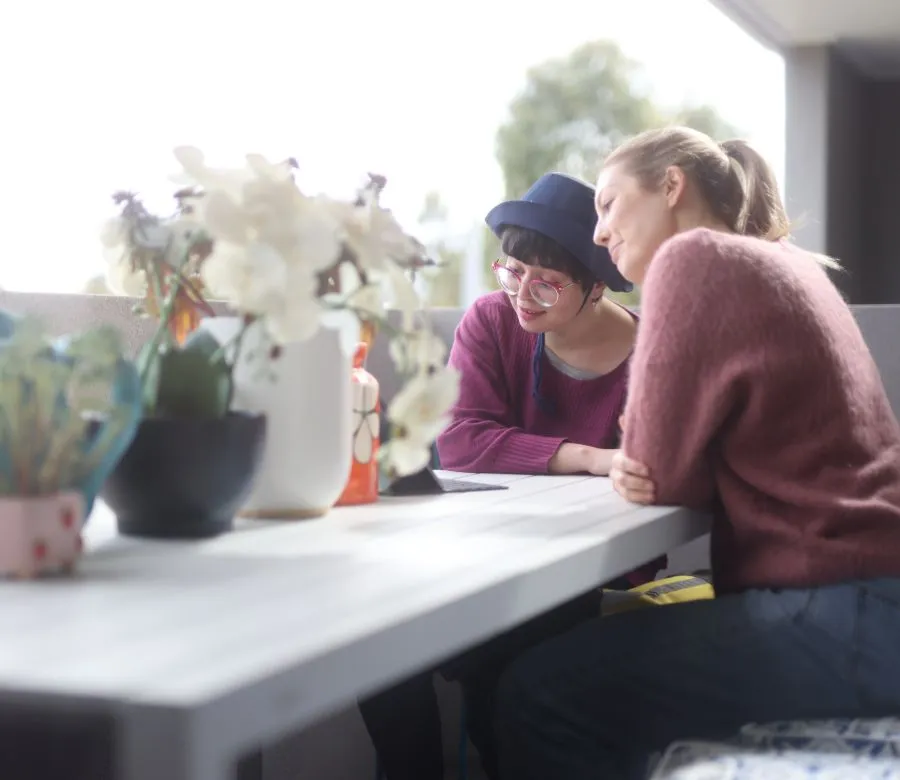 Support worker writing a short visit note after a home visit in Darebin