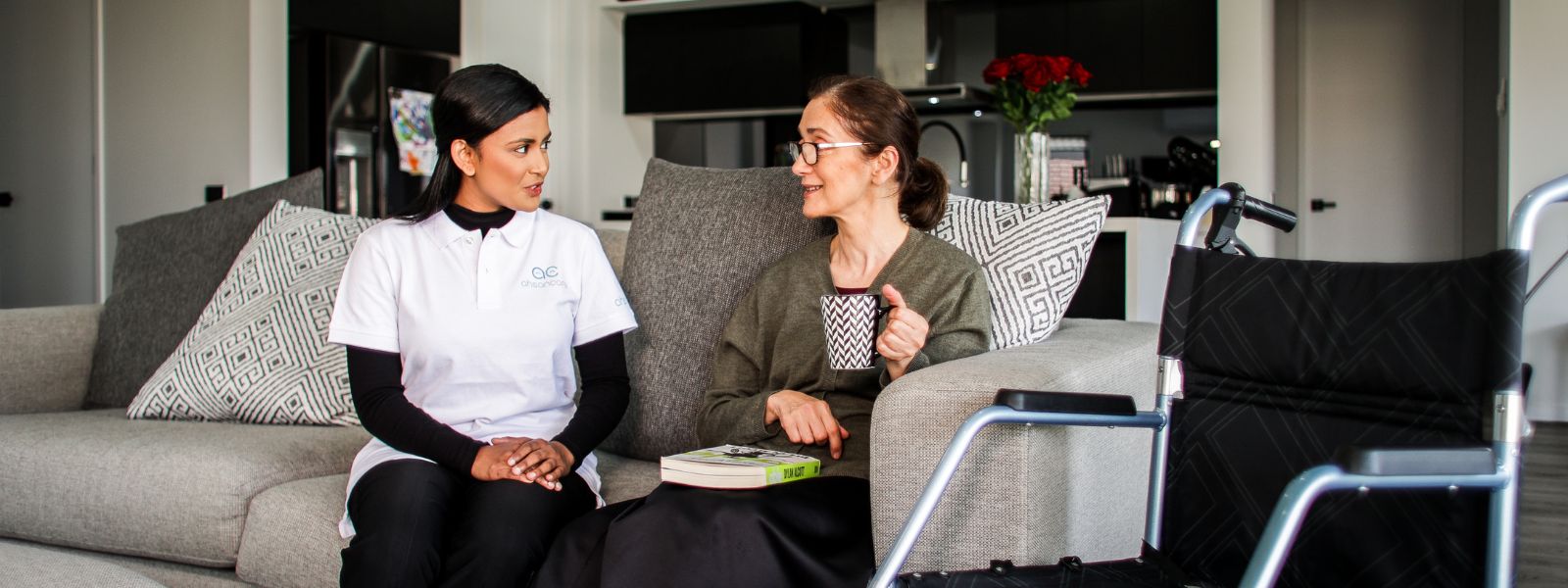 Support worker and participant in a Sydney home or local street setting. Western Sydney context, culturally diverse, natural rather than staged.