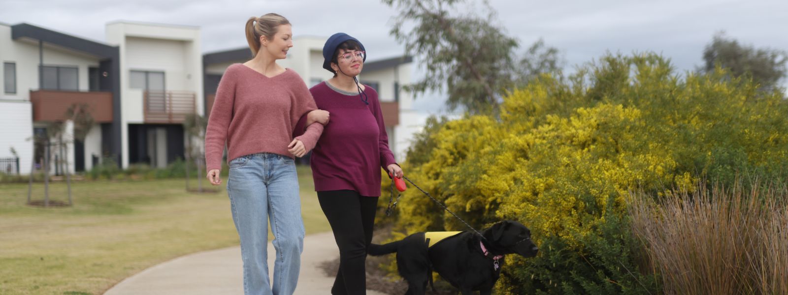 Support worker and NDIS participant walking together in a Casey park