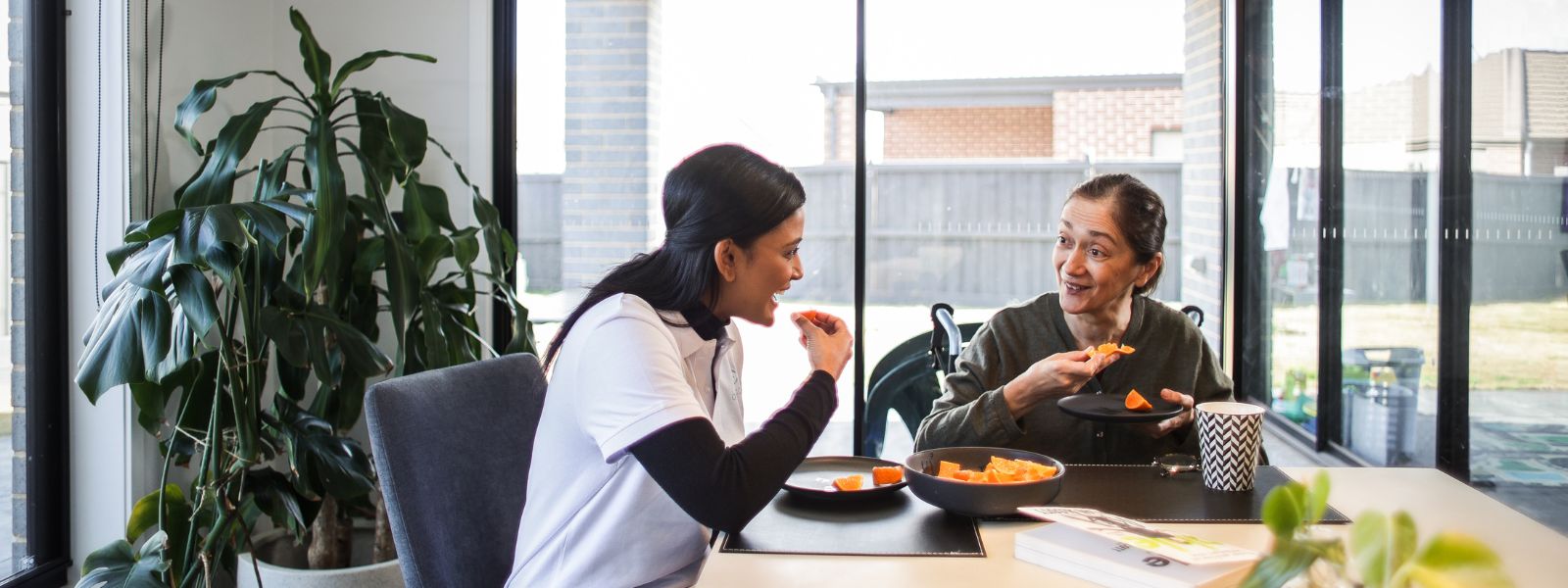 A support worker and participant talking together at home in Hume